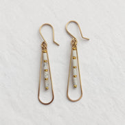 Bijou by SAM First Snow teardrop hoop earrings featuring white Howlite tube beads and 14k gold fill wire.