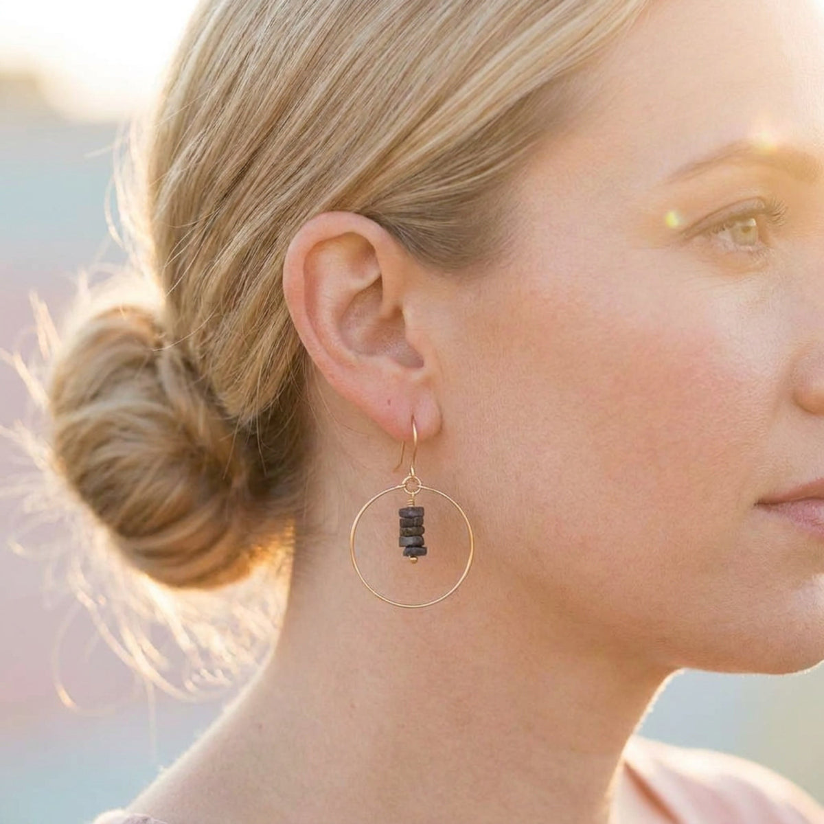 Bijou by SAM gold hoop earrings featuring a delicate stack of deep blue square-cut iolite gemstones on a model