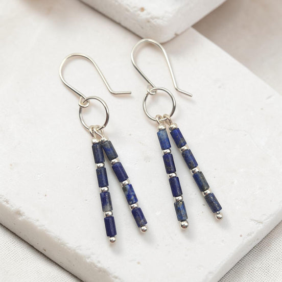 Bijou by SAM Midnight Sky earrings featuring deep blue Lapis Lazuli tube beads and silver spacers on hoop dangles.