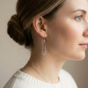 Bijou by SAM Midnight Sky teardrop earrings with blue Lapis Lazuli beads on a model wearing a white sweater.