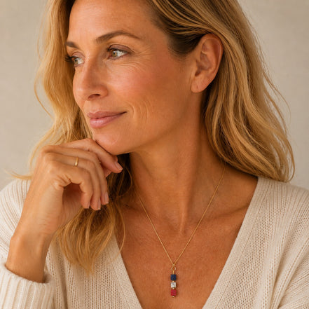 Bijou by SAM Liberty necklace featuring red, white, and blue sea sediment jasper cubes on a gold chain worn by a woman.