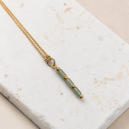 Bijou by SAM Mossy Creek necklace featuring green aventurine tube beads and 14k gold fill chain on a stone surface.