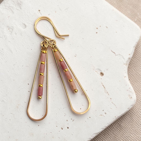Bijou by SAM Rose Bluff teardrop earrings with pink rhodonite tube beads and 14k gold fill hoops on white stone.