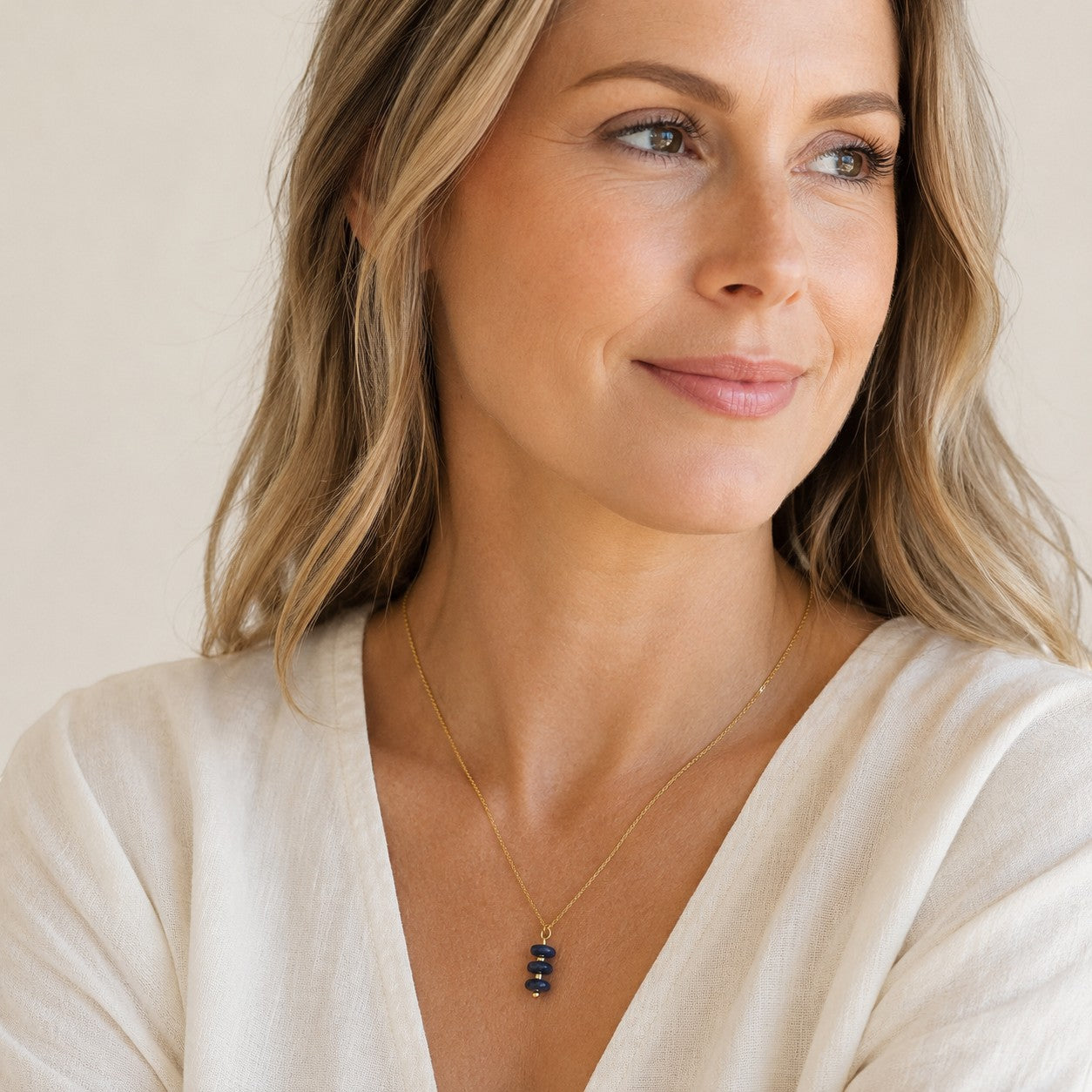 Bijou by SAM Milky Way necklace featuring three deep blue sodalite gemstones on a delicate gold chain worn by a woman