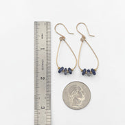 Bijou by SAM Milky Way teardrop hoop earrings with blue sodalite stones and gold fill wire shown next to a ruler and coin