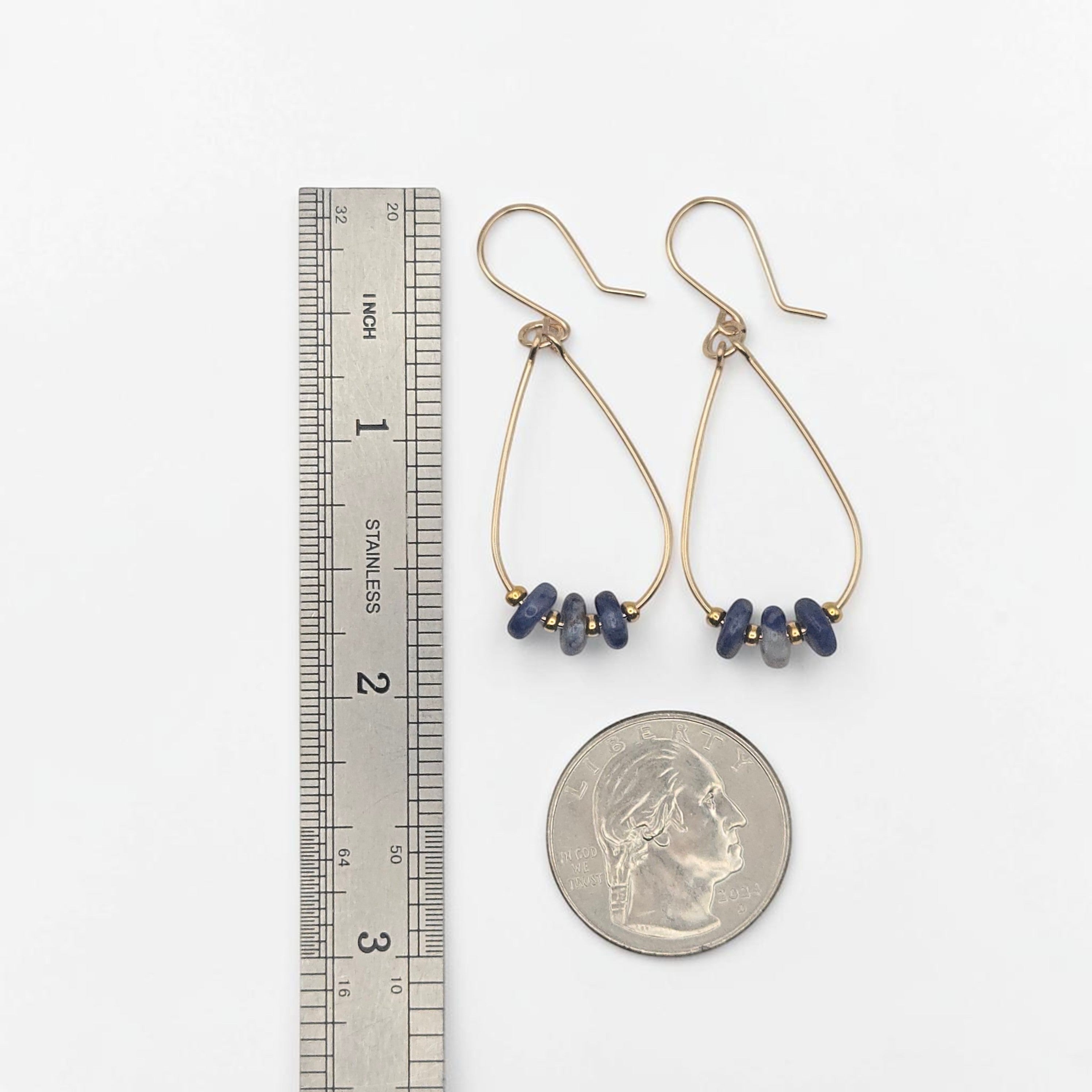 Bijou by SAM Milky Way teardrop hoop earrings with blue sodalite stones and gold fill wire shown next to a ruler and coin