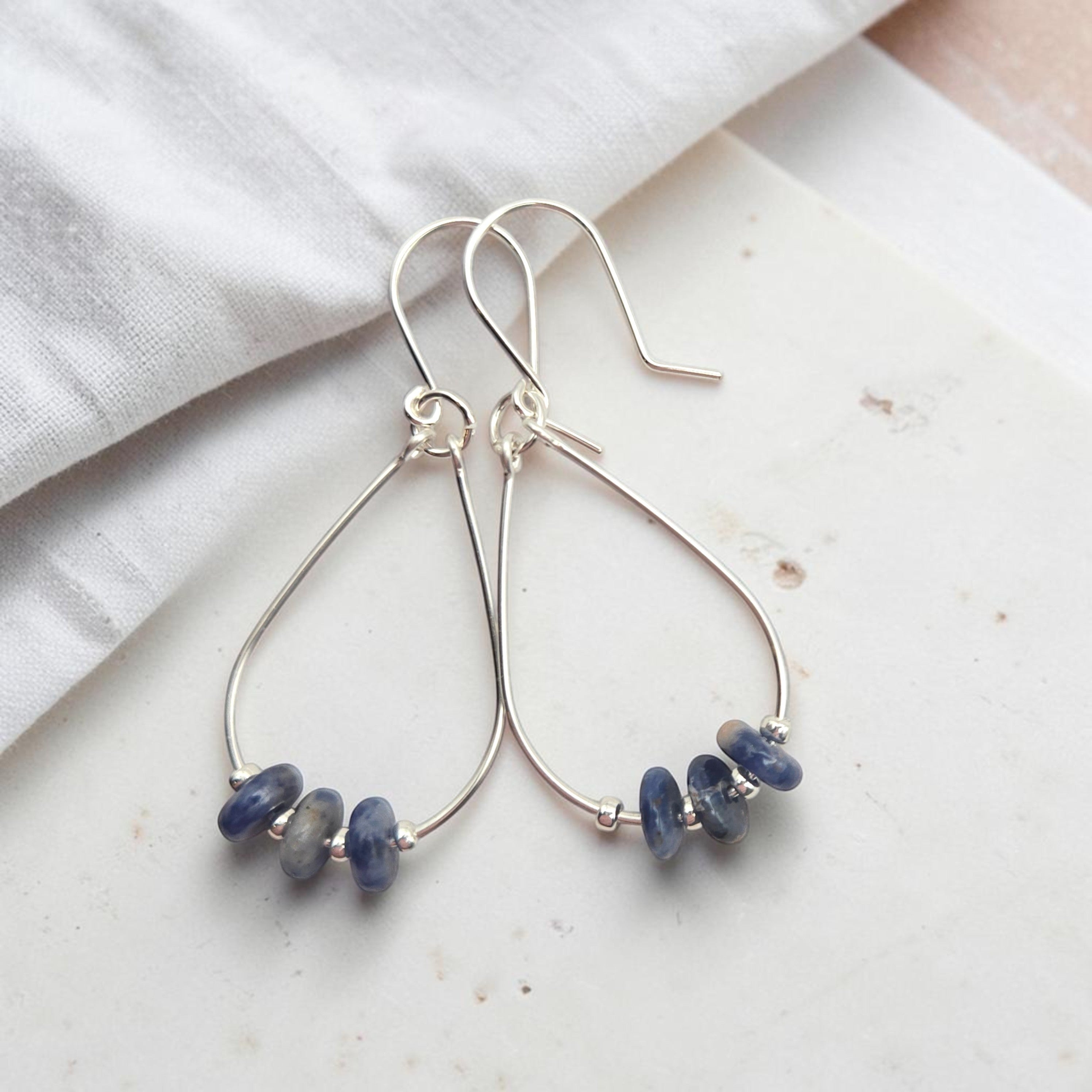 Bijou by SAM Milky Way teardrop hoop earrings featuring deep blue sodalite stones on sterling silver wire.