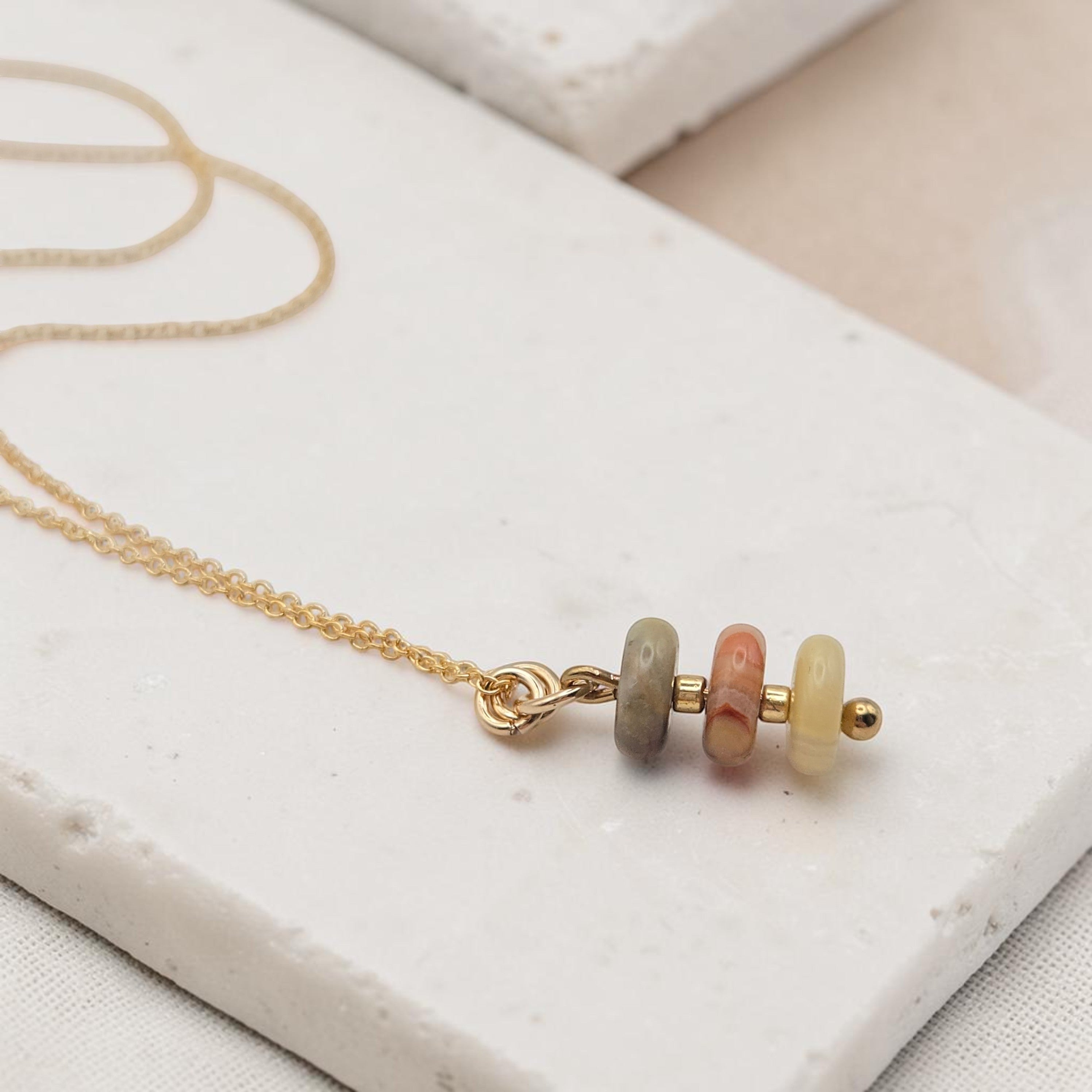 Bijou by SAM Stardust necklace featuring three small crazy lace agate stones in cream, coral, and tan on a gold chain.