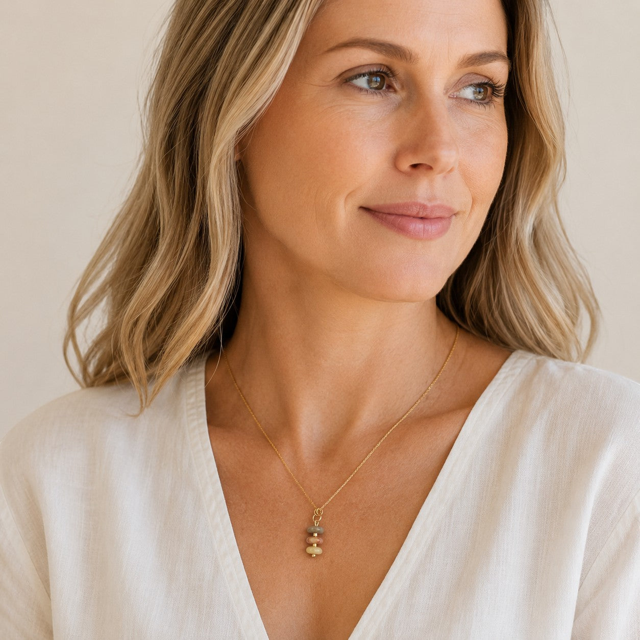 Bijou by SAM Stardust necklace featuring three stacked crazy lace agate stones on a delicate gold chain worn by model