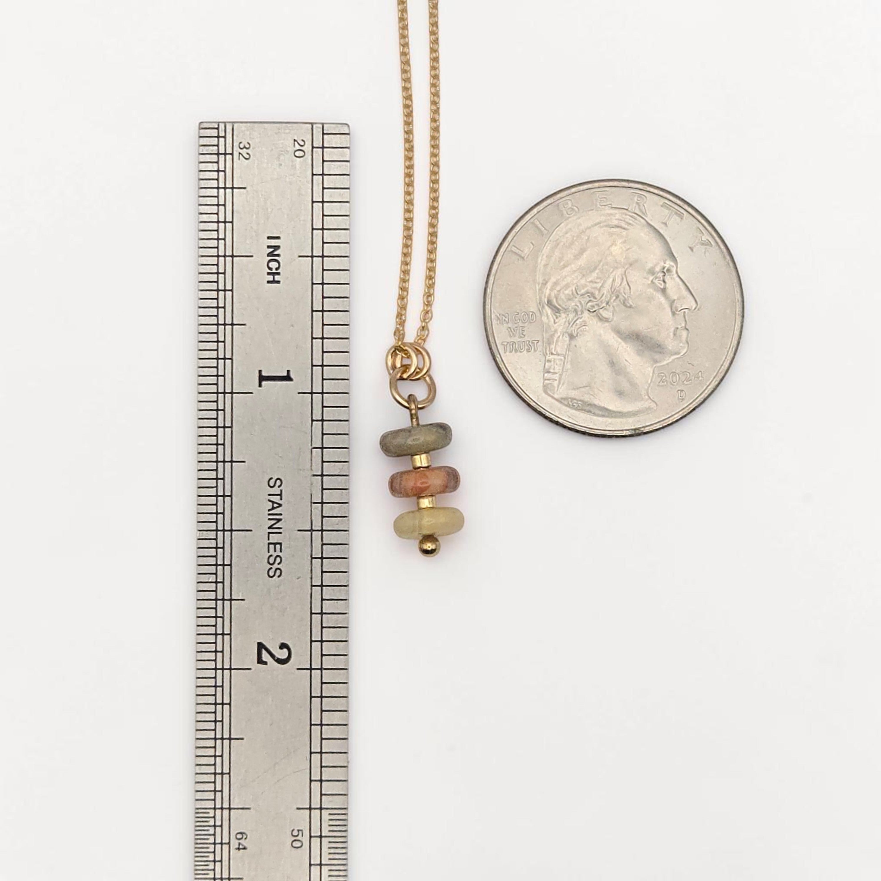 Bijou by SAM Stardust necklace featuring three small crazy lace agate beads on a delicate gold chain next to a ruler.