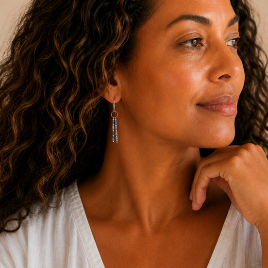 Bijou by SAM Stone Creek earrings featuring blue spot jasper tube beads on sterling silver hoops worn by a woman.