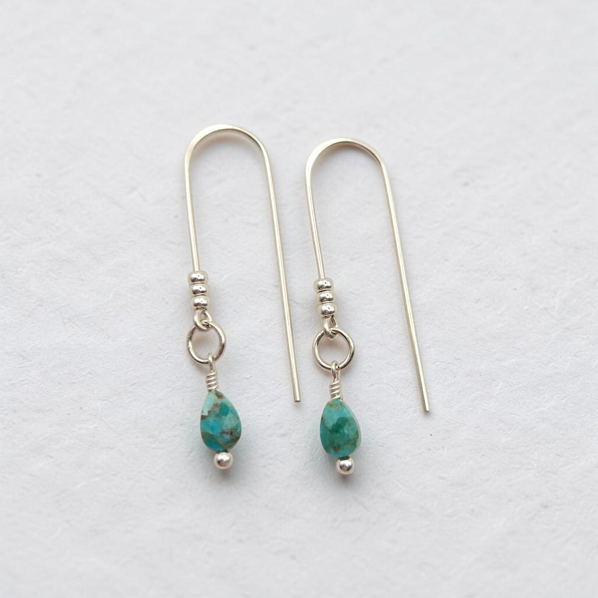 Bijou by SAM handcrafted silver threader earrings featuring genuine teardrop turquoise gemstones on a white background