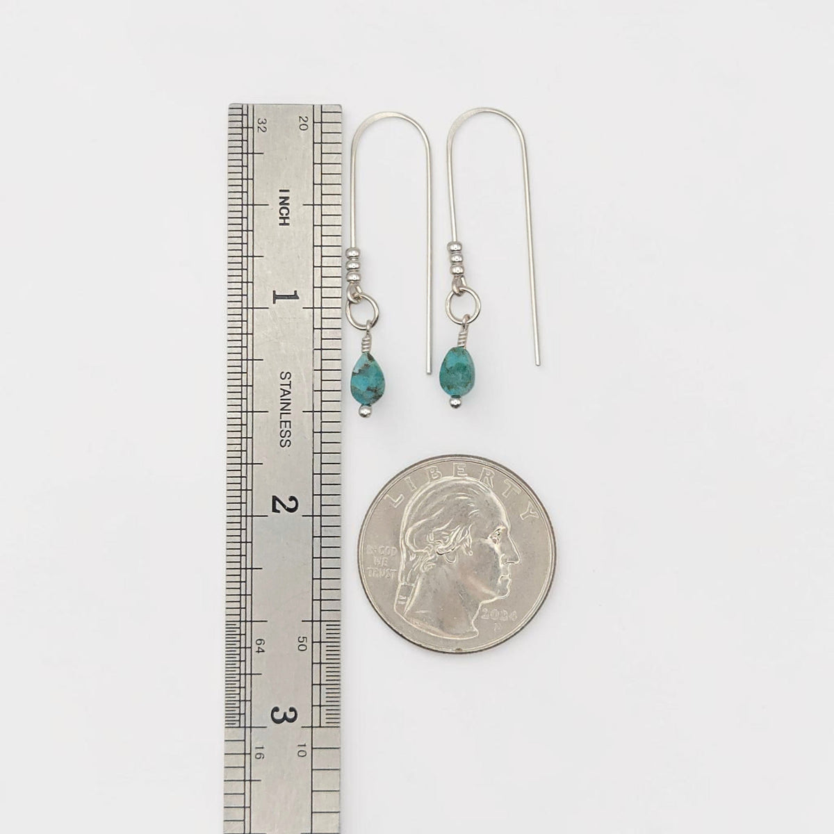 Bijou by SAM handcrafted sterling silver threader earrings featuring genuine teardrop turquoise stones next to a ruler