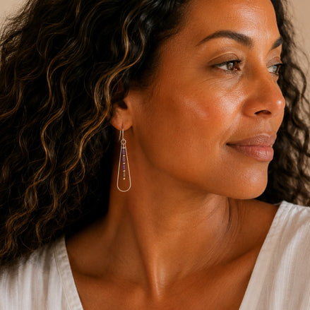 Bijou by SAM Twilight Ridge teardrop earrings with purple amethyst tube beads on a model wearing a white top.