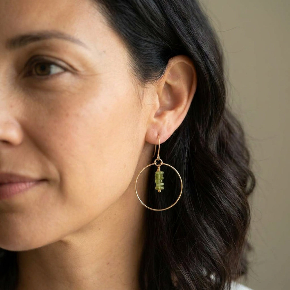 Bijou by SAM handmade gold hoop earrings featuring a delicate stack of square-cut green Vesuvianite stones on a model