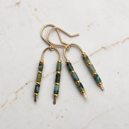 Bijou by SAM wishbone earrings featuring African Turquoise tube stones and 14k gold fill wire on a marble surface.