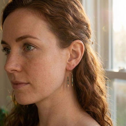 Bijou by SAM wishbone earrings featuring African Turquoise tube stones on 14k gold fill wire worn by a woman