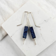 Blue stone earrings on a marble surface