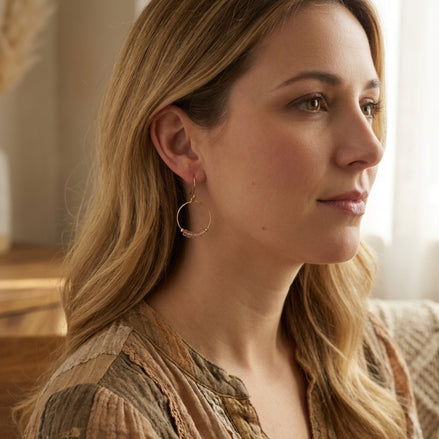Woman with long blonde hair wearing hoop earrings indoors