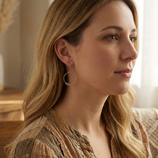 Woman with long blonde hair wearing hoop earrings indoors