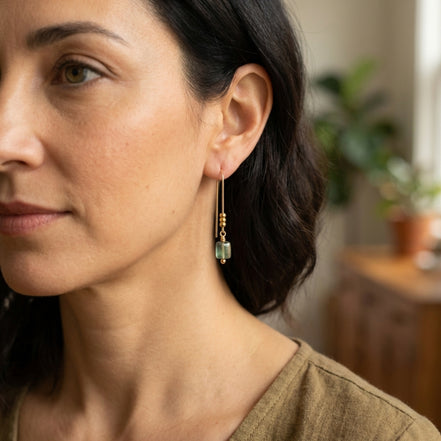 Close-up of a woman wearing earrings with a blurred indoor background