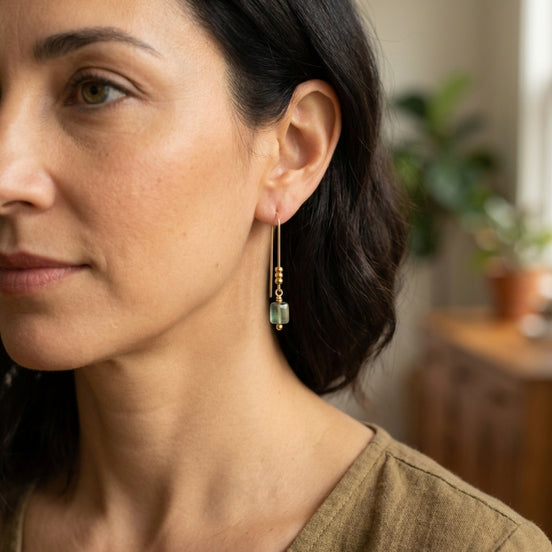 Close-up of a woman wearing earrings with a blurred indoor background