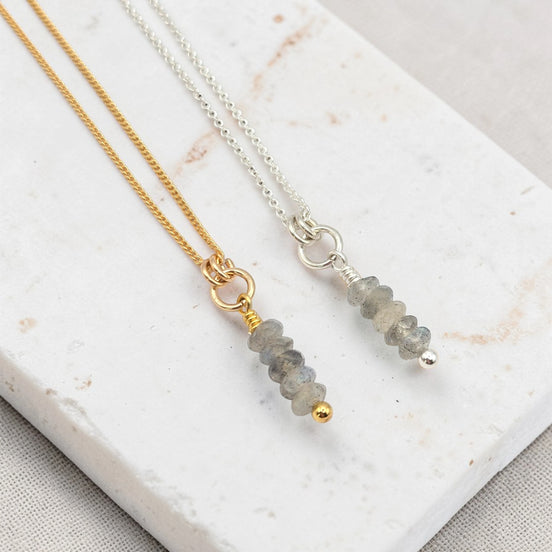 Two necklaces with Labradorite beads on a marble surface