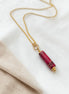 Necklace with a red cylindrical pendant on a white background
