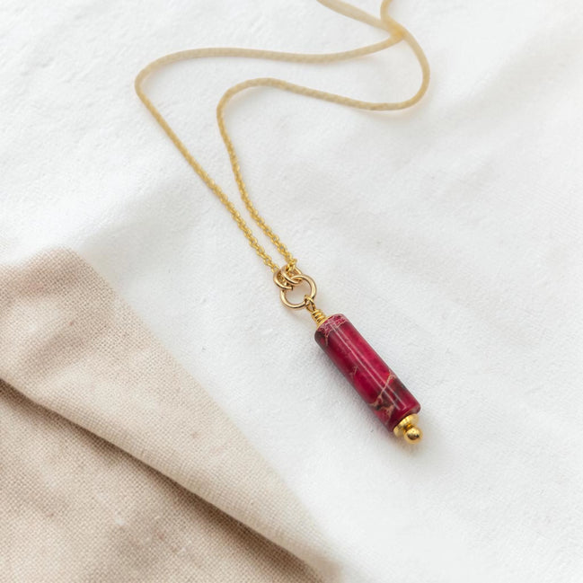 Necklace with a red cylindrical pendant on a white background