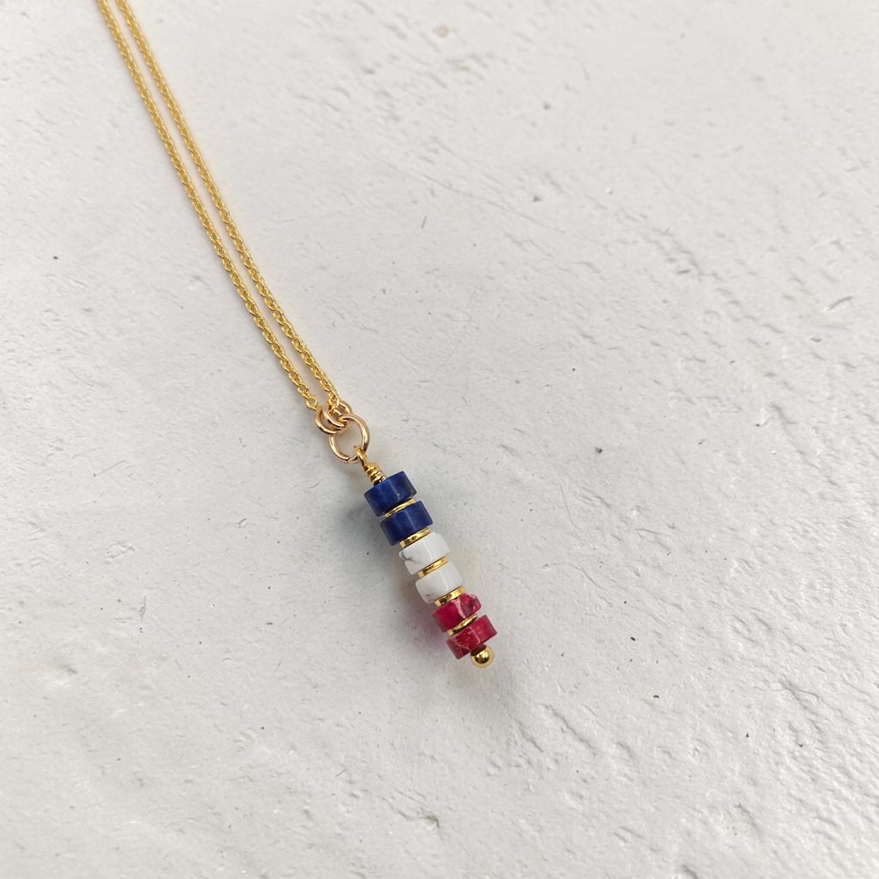 Necklace with colorful beaded pendant on a light gray background