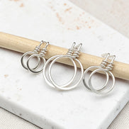 set of three handmade sterling silver hoop stud earrings on a concrete surfacte